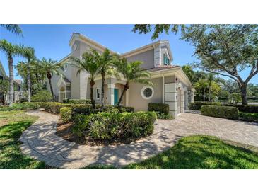 Beautiful exterior showcasing lush landscaping, complemented by a paver walkway and a charming, light-colored facade at 5283 Descanso Ct # 101B18, Sarasota, FL 34238