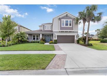 Beautiful two-story home showcasing a lush, green lawn, well-manicured landscaping and a spacious driveway at 5978 Anise Dr, Sarasota, FL 34238
