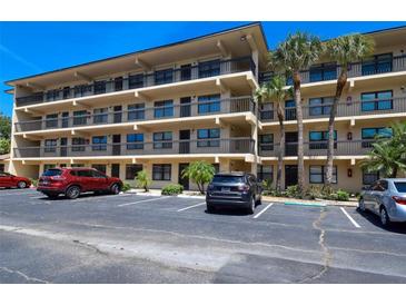 Condominium exterior featuring multiple balconies, parking, and palm trees at 625 30Th W Ave # G210, Bradenton, FL 34205