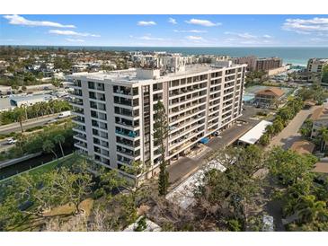 Stunning high-rise condo building with many balconies overlooking the ocean and beach in a tropical landscape at 6415 Midnight Pass Rd # 204, Sarasota, FL 34242