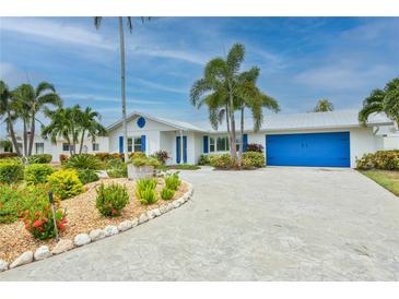 Charming single-story home with colorful landscaping, a blue garage door, and well-maintained exterior at 10108 Kingfisher E Rd, Bradenton, FL 34209