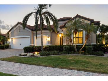 Charming home featuring a tile roof, a well-manicured lawn, and lush landscaping at 16309 Castle Park Ter, Lakewood Ranch, FL 34202