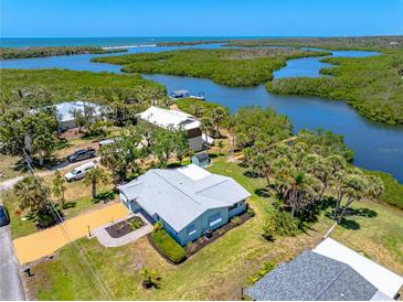 An aerial view of the charming home showcasing a waterfront location and lush landscaping at 1680 Lemon Bay Dr, Venice, FL 34293