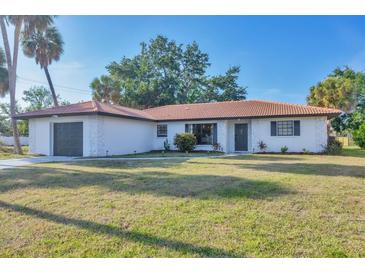 Charming single-story home with a terra cotta tile roof and lush front lawn at 2301 Cass St, Sarasota, FL 34231