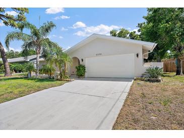 Charming single Gathering home boasting a well-manicured lawn, spacious driveway, and a two-car garage at 3370 Harbor Lake Dr, Largo, FL 33770