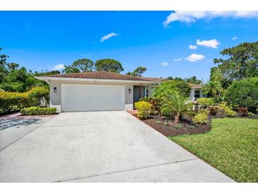 Charming single Gathering home boasts a well maintained front yard with mature tropical landscaping, and a two-car garage at 5603 Ravenwood Dr, Sarasota, FL 34243