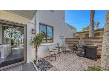 Cozy outdoor patio with brick pavers, seating, grill, and decorative fish art, perfect for relaxing at 564 Lakeside Dr # 564, Bradenton, FL 34210
