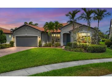 Charming single-story home with lush lawn, mature landscaping, and a terracotta tile roof at 5923 Snowy Egret Dr, Sarasota, FL 34238