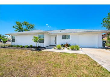Charming single-story home features fresh white paint, a well-manicured lawn and simple landscaping at 6698 Acmar Ct, North Port, FL 34287