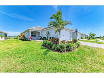 Beautiful single-story home boasts a well-manicured lawn, tropical landscaping, and a charming two-car garage at 1007 Waterline Ct, Sarasota, FL 34240