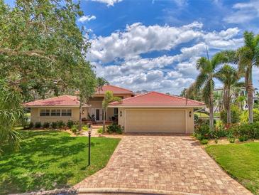 Charming single-Gathering home with a red-tiled roof, brick driveway, and tropical landscaping at 1038 Contento St, Sarasota, FL 34242