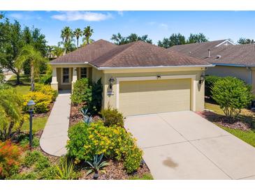 Charming single-story home featuring a two-car garage, well-manicured landscaping, and a concrete driveway at 11634 Piedmont Park Xing, Bradenton, FL 34211