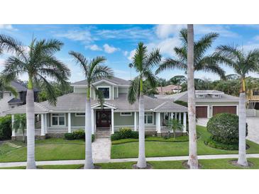 Inviting home with lush landscaping, palm trees, and charming front porch, creating a welcoming curb appeal at 1910 Datura St, Sarasota, FL 34239