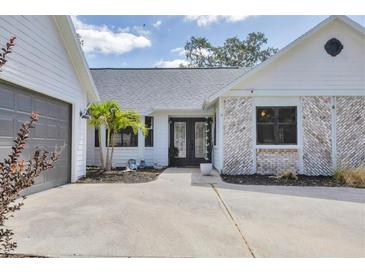 Beautiful home with a gray garage door and an accent of white brick on the front exterior at 2049 E Leewynn Dr, Sarasota, FL 34240