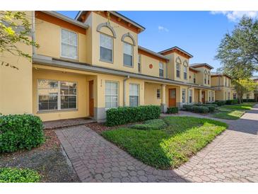 Charming townhome with well-maintained landscaping, a brick walkway, and a colorful, inviting exterior at 220 Coquina Bay Dr, St Petersburg, FL 33705