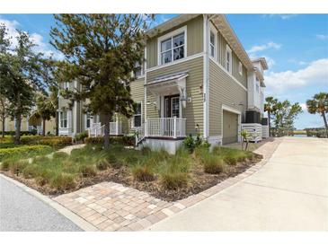 Charming two-story home featuring green siding, a quaint front porch, and a well-maintained, landscaped yard at 230 Sapphire Lake Dr # 201, Bradenton, FL 34209