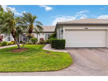 Charming single-story home featuring a two-car garage, lush landscaping, and a well-manicured lawn at 3130 Ringwood Mdw # 44, Sarasota, FL 34235