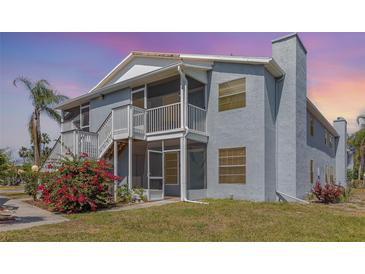 Light blue condo with screened porch, balcony, flowering bushes, and painted stairs at 3781 59Th W Ave # 3781, Bradenton, FL 34210