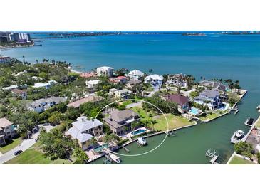 Stunning aerial view of waterfront property featuring a pool, boat dock, and lush landscaping at 975 Whitakers Ln, Sarasota, FL 34236