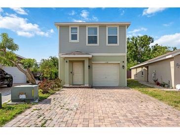 Two-story home featuring a charming front entrance, brick driveway, attached garage, and neutral paint colors at 1122 42Nd E Ter, Bradenton, FL 34208