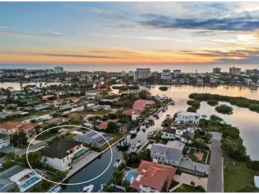 Beautiful sunset aerial view of the waterfront home with private pool and access to the bay and Gulf of Mexico at 1643 Stanford Ln, Sarasota, FL 34231