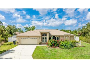 Charming single-story home featuring a well-manicured lawn, mature landscaping, and an attached two-car garage at 1667 Oakland Rd, North Port, FL 34286