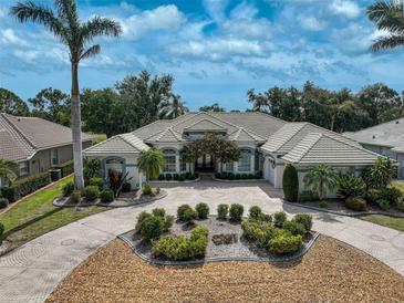 Stunning home featuring lush landscaping, a circular driveway, and a beautiful tile roof at 2111 Muskogee Trl, Nokomis, FL 34275