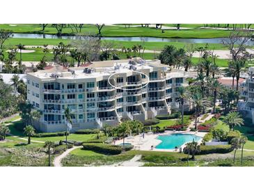 Multi-story condominium features beautiful landscaping, a pool, and golf course views at 2185 Gulf Of Mexico Dr # 243, Longboat Key, FL 34228