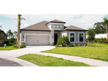 Charming single-story home with a well-maintained lawn and attached two-car garage at 5684 Blue Reef Place, Nokomis, FL 34275