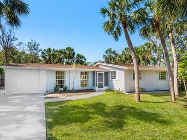 Charming single-story home with palm trees, a brick facade, and a well-manicured lawn at 734 Canal Rd, Sarasota, FL 34242