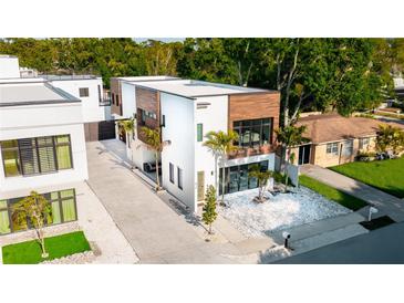 Modern home's exterior featuring clean lines, wood accents, a well-maintained yard, and an inviting facade at 816 Goodrich Ave, Sarasota, FL 34236