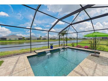 Beautiful screened-in pool with waterfall features overlooking a serene lake at 12330 Halfmoon Lake Ter, Bradenton, FL 34211