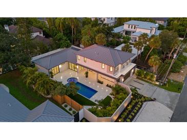 Aerial view showcasing a modern home with a large pool, lush landscaping, and expansive outdoor living areas at 1559 Bay Rd, Sarasota, FL 34239