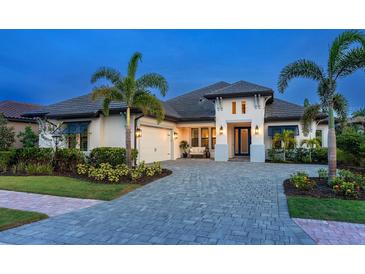 Beautiful single-Gathering home features lush landscaping, a brick paved driveway, and a grand entryway with double doors at 16614 Berwick Ter, Lakewood Ranch, FL 34202