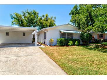 Charming single-story home featuring a well-manicured lawn and an attached carport at 2435 Terry Ln, Sarasota, FL 34231