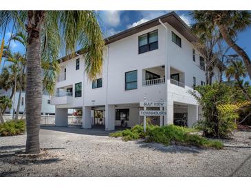 Beautiful three-story townhouse featuring covered parking and lush tropical landscaping at 3701 5Th Ave # 1, Holmes Beach, FL 34217