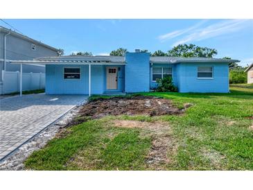 Charming single-story home featuring a covered carport, brick chimney and a freshly landscaped front yard at 4512 26Th S Ave, Tampa, FL 33619