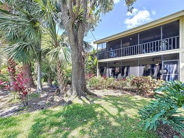 Scenic backyard showcasing lush foliage and mature trees with view of screened-in patio at 5234 Lake Arrowhead Trl # 30, Sarasota, FL 34231