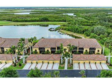 Beautiful condo building exterior featuring tropical landscaping and tile roofs at 7315 River Hammock Dr # 101, Bradenton, FL 34212