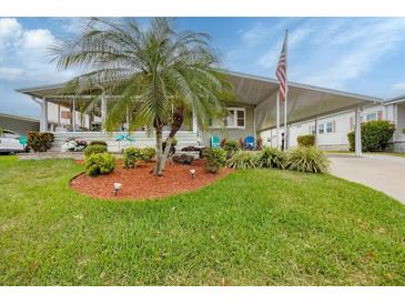 Charming home featuring a landscaped front yard with a beautiful palm tree at 1507 45Th Avenue E Dr, Ellenton, FL 34222
