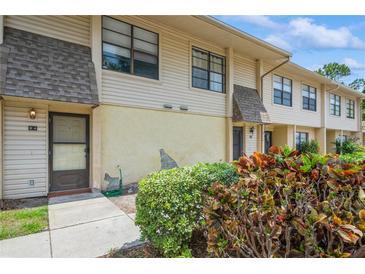 Inviting townhouse exterior with tan siding, front door, manicured bushes, and a small front yard at 3610 54Th W St # B4, Bradenton, FL 34209