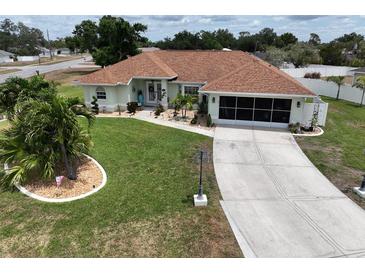 Charming single-story home with well-manicured lawn, decorative landscaping, and long driveway at 3984 Holin Ln, North Port, FL 34287