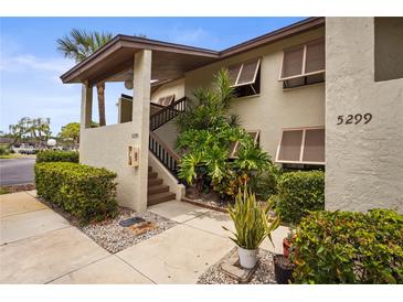 A well-maintained two-story condo building features a well manicured landscape and shuttered windows at 5291 Willow Links # 54, Sarasota, FL 34235