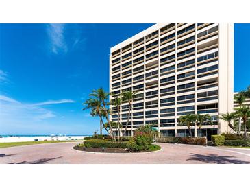 Luxury high-rise condo building overlooking a beautiful beach with tropical landscaping at the entry at 5966 Midnight Pass Rd # G-51 & G-58, Sarasota, FL 34242
