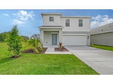 Beautiful two-story home featuring a blue front door, two-car garage, and green lawn at 13116 Bayberry Way, Parrish, FL 34219