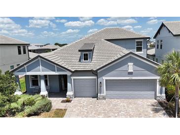 Beautiful single-Gathering home with a gray roof and three-car garage on a sunny day at 16905 Sweetwater Village Dr, Bradenton, FL 34211
