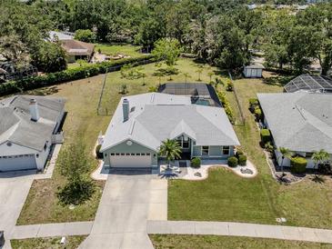 Charming single Gathering home featuring a spacious lawn, attached garage, and screened-in backyard pool at 245 Woodingham Trl, Venice, FL 34292