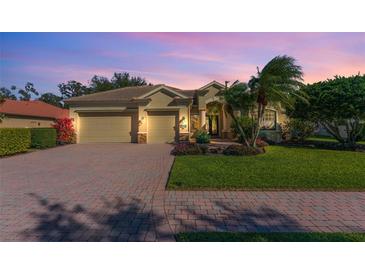 Beautiful single-story home with a well-manicured lawn, brick driveway, and a two-car garage at 4579 Tuscana Dr, Sarasota, FL 34241