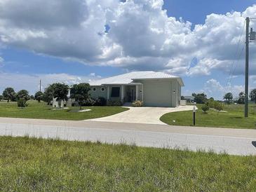Charming single-story home with a well-manicured lawn and a circular driveway and lush green surroundings at 48 Lark Dr, Placida, FL 33946