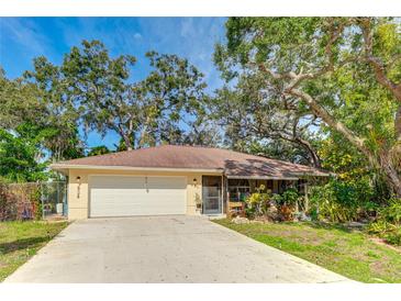 Charming single-story home with a two-car garage and mature landscaping at 620 Burke Rd, Venice, FL 34293